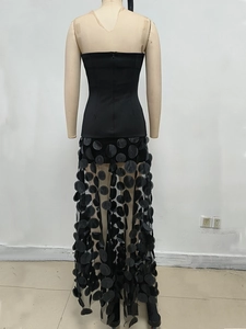 Detail of black strapless evening dress featuring 3D circular sequins on sheer mesh skirt