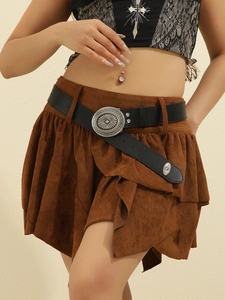 Detail of vintage black leather belt with silver buckle on a brown layered skirt