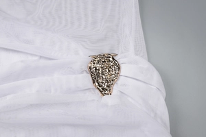 Détail de maille blanche transparente avec boucle métallique dorée irrégulière
