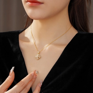 Détail du collier trèfle plaqué or avec perles porté par un mannequin féminin