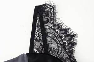 Detalle de encaje floral negro sobre un vestido ajustado gris oscuro elegante