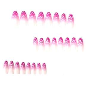 Pink ombre almond press-on nails with white heart patterns and glitter accents