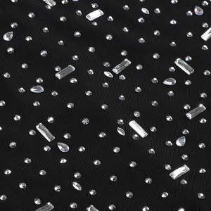 Detailed view of sparkling rhinestones and crystal beadwork on elegant black mesh fabric