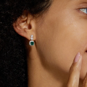 Macro view of S925 silver earrings with green emerald square stone and round crystals