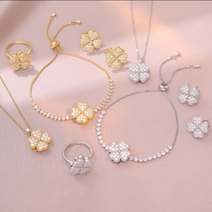 Detailed jewelry set with zircon clover necklace, bracelet, ring and earrings