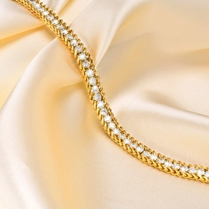 Detailed close-up of double-row gold-plated bracelet with pavé white zircons on silk
