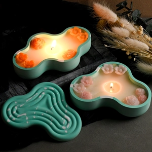 Artistic wavy textured candles with 3D floral decorations on a black lace background