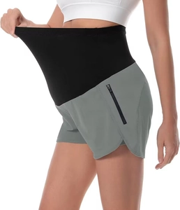 Dettaglio di pantaloncini sportivi premaman con supporto addominale alto e tasche con zip