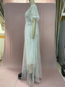 Close-up of white lace wedding dress with floral 3D embroidery and polka dot mesh