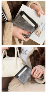 Detail of slim grey faux leather card holder with denim texture and gold ring clip