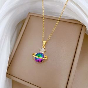 Macro shot of gold-plated Saturn pendant necklace with colorful crystals on soft background
