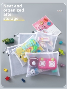 Detailed view of white mesh storage bags organized with various children's toys and zipper