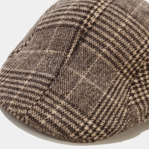 Close-up of brown houndstooth wool blend fabric on a vintage newsboy cap