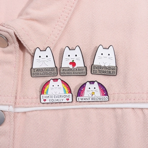 Detailed view of five cute cat enamel pins attached to a pink denim jacket collar
