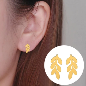 Detail view of gold leaf stud earrings with realistic ear model and product close-up