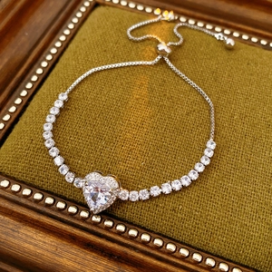 Detail of heart zircon bracelet with adjustable slider clasp on green velvet background