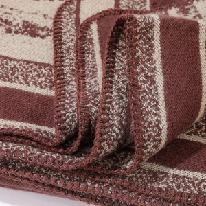 Detail van zachte bruine en beige gebreide stof met etnische patronen en fijne stiksels