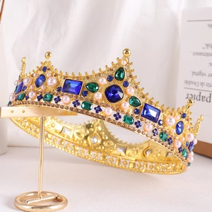 Detail of Baroque queen crown with blue and green gems and elegant pearls in gold setting