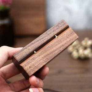 Close-up of walnut wood ring box with brass hardware details and natural grain