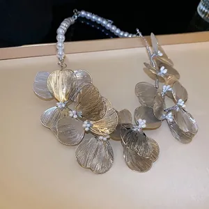 Champagne gold cutout metal flower necklace with elegant white pearls and brushed texture