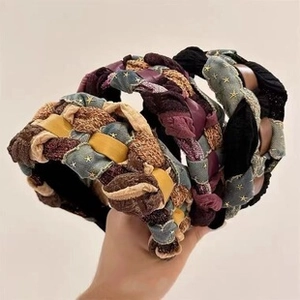 Detailed view of three woven fabric headbands with star patterns held by hand