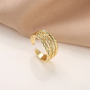 Detail of a triple-layered twisted gold open ring featuring a textured rope design