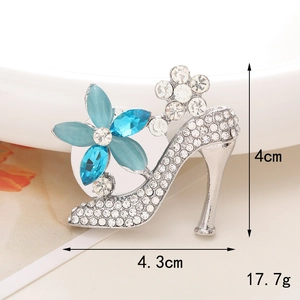 Macro shot of silver high heel brooch with blue marquise stones and pearl detail