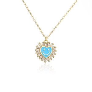 Detail of a gold heart pendant with blue enamel smiley face and rectangular zircon trim