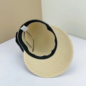 Detail of adjustable black inner strap and straw texture on beige bow visor hat