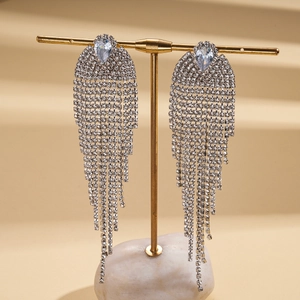 Macro detail of geometric tassel earrings with micro-pave cubic zirconia on a gold stand