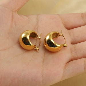 Retro 18K gold-plated spherical hollow stainless steel hoop earrings held in palm