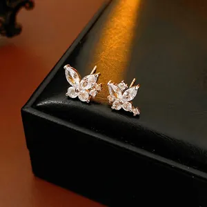 Boucles d'oreilles papillon plaquées or avec zircons cubiques sur écrin en cuir noir