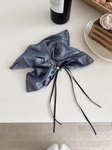 Détail du chouchou scintillant bleu marine avec nœud, ruban, perle blanche et cristal
