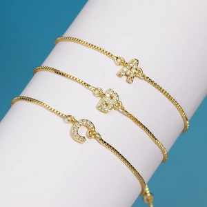 Vue détaillée de bracelets en cuivre doré avec charms lettres A, B, C et pierres zircon