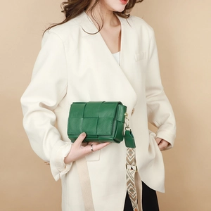 Detail of emerald green woven leather square bag with jacquard and plain straps