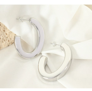 Polished silver C-shaped earrings with white enamel inlay and soft silicone backings