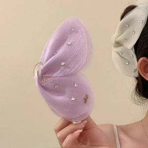 Detalle de la pinza para el pelo de mariposa en malla elegante con pedrería brillante