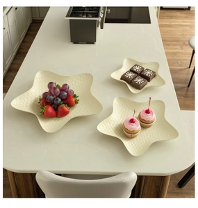 Set of three cream star-shaped serving plates with textured finish on marble surface