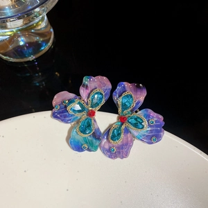 Detail of vintage flower stud earrings featuring purple gradient resin and crystal accents
