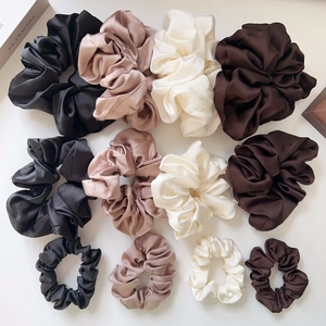 Detailed comparison of satin scrunchies in four colors and three sizes on white surface