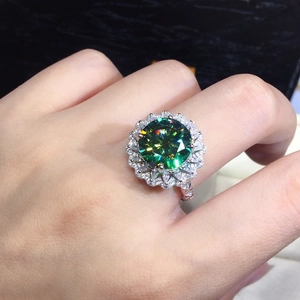 Macro detail of luxury green moissanite ring with sunflower halo setting and brilliant fire