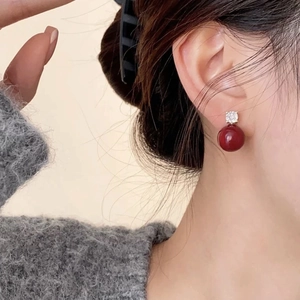 Boucles d'oreilles pendantes perle rouge et zircon, style minimaliste porté sur modèle