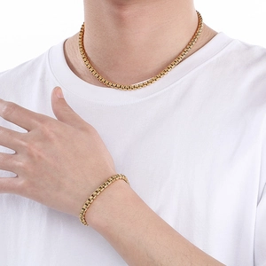 Close-up of golden stainless steel square pearl necklace and bracelet set on model