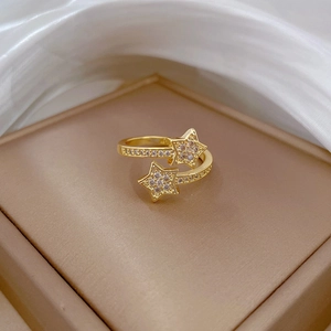Macro view of gold plated star ring with white zircon pave setting on silk