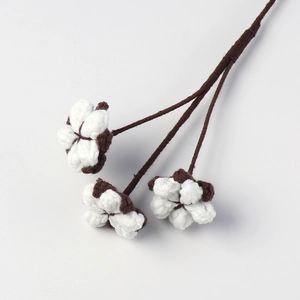 Close-up of a handmade cotton flower stem with white fluffy heads and brown dried sepals