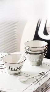 Detail of modern ceramic bowl set with silver metallic finish and matching long spoon