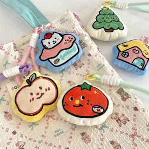 Detail showing five assorted plush bag charms with embroidery on a white quilted bag