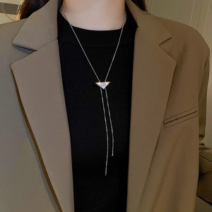 Macro detail of Y-shaped snake chain necklace with sparkling diamond-set triangle pendant