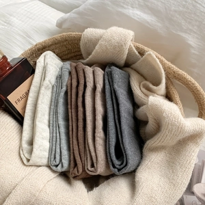 Close-up of four colors textured knit cotton mid-calf socks neatly stacked in a basket