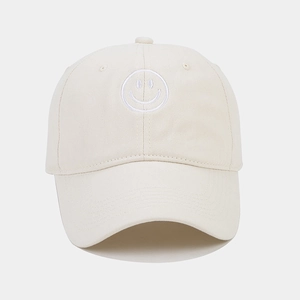Close-up of embroidered smiley face on off-white cotton twill baseball cap crown